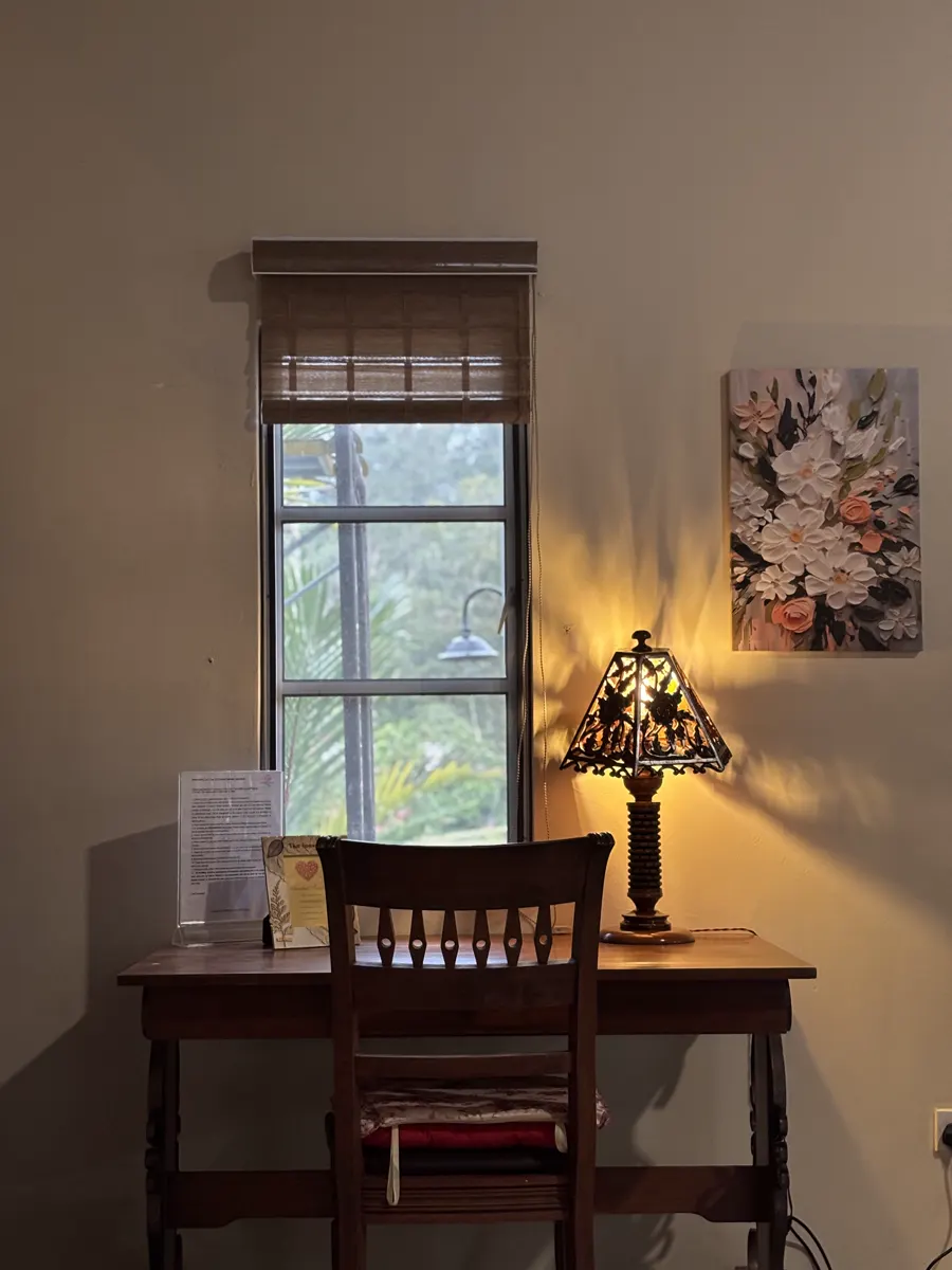 A quiet reading corner with a stained-glass lamp beside a tall window
